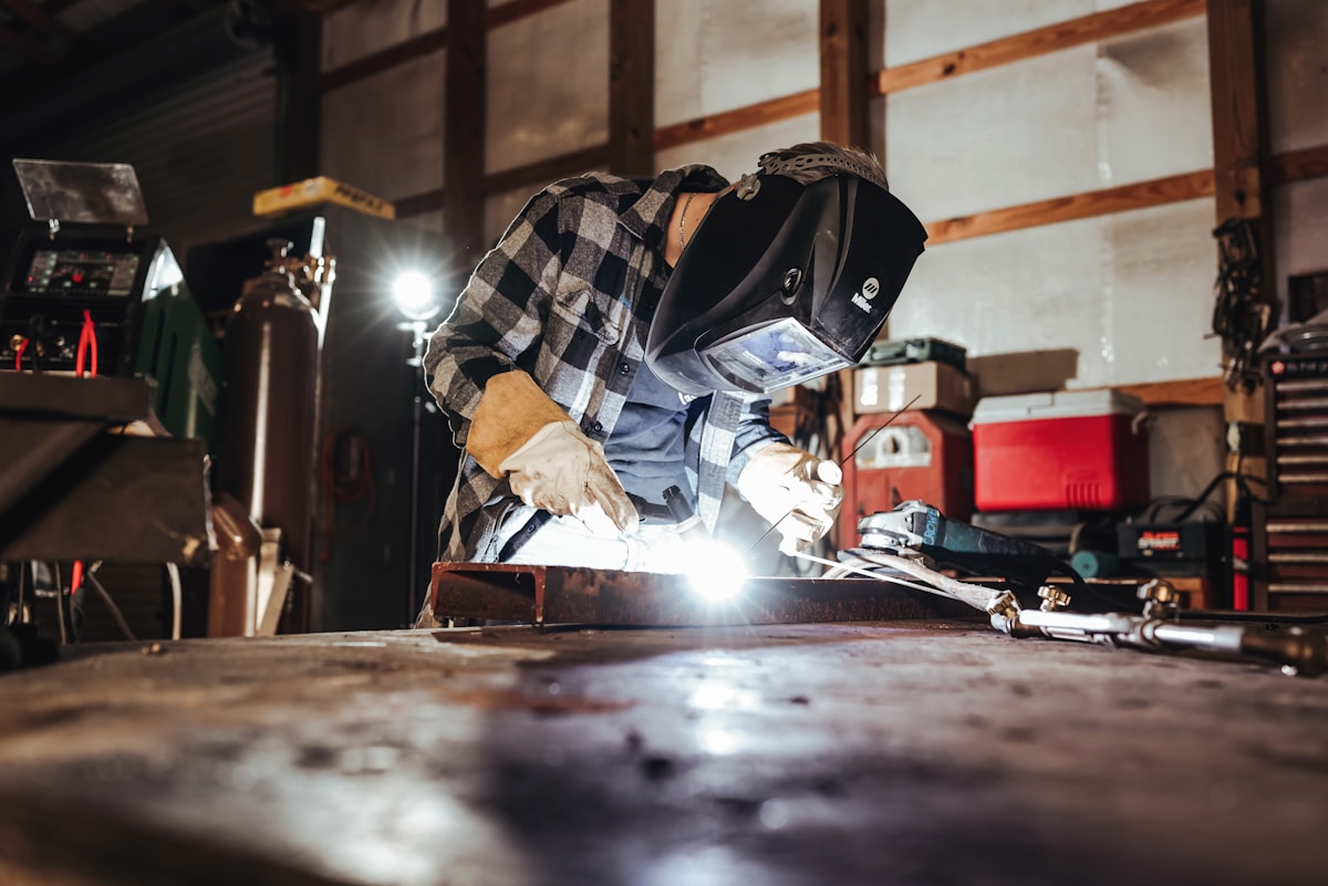 Welder working metal with protective gloves and sparks